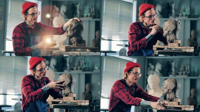 男雕塑家正在工作室里固定一个粘土头。灵感，创造性的工作理念。