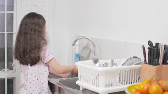 亚洲小女孩在帮妈妈做家务，在厨房洗碗