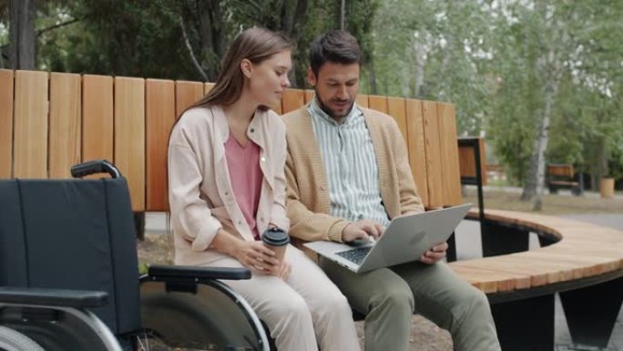 残疾男女在公园里用笔记本电脑喝酒去户外喝咖啡