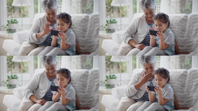 小女孩用智能手机和祖母在家庭分享假期周末挥手视频聊天和奶奶在手机上聊天和孙女4k在家放松