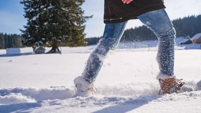 用绑在脚上的雪鞋在新鲜落下的粉末雪上徒步旅行