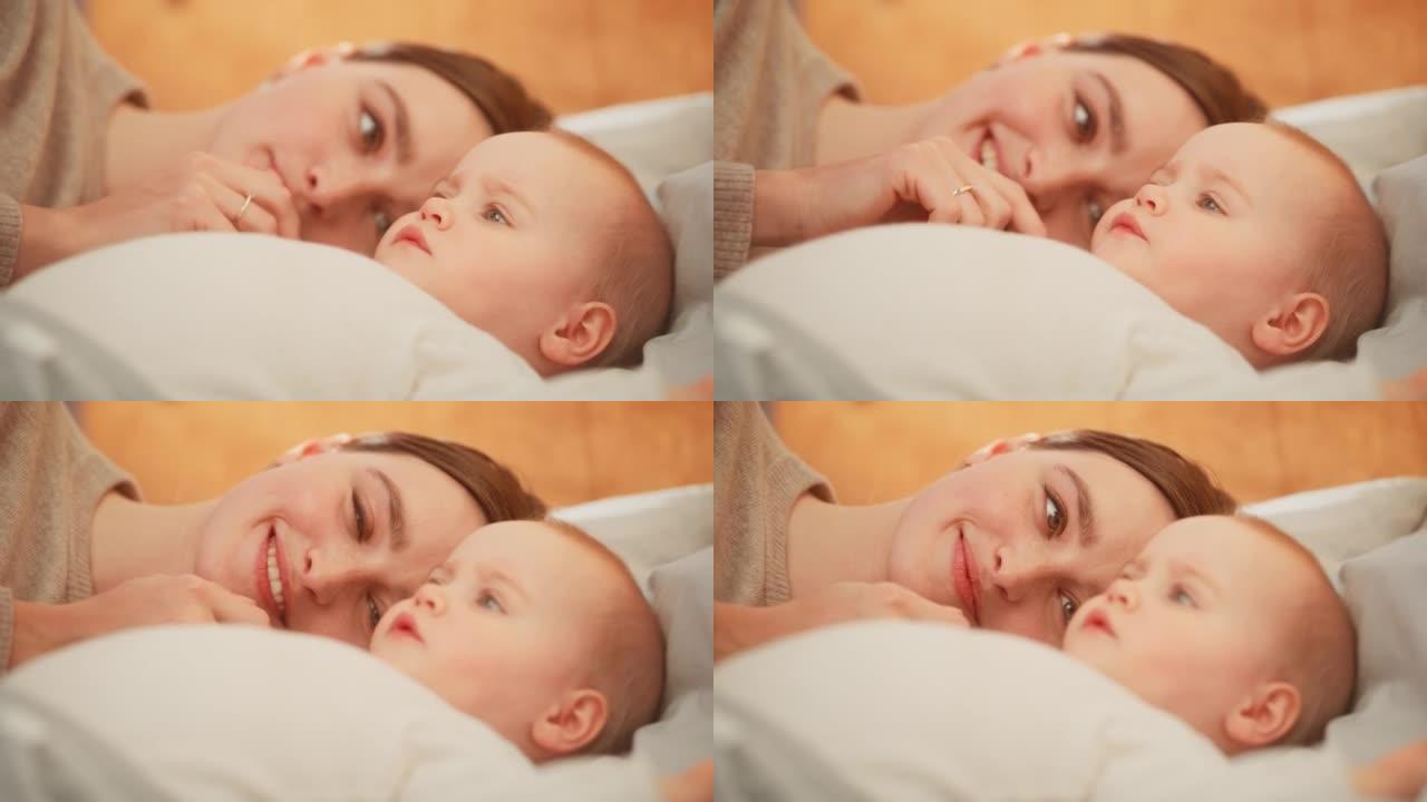 一个快乐的母亲和一个可爱的新生婴儿玩耍的特写镜头。妈妈和一个蹒跚学步的孩子在一起，轻轻地抚摸女孩的脸