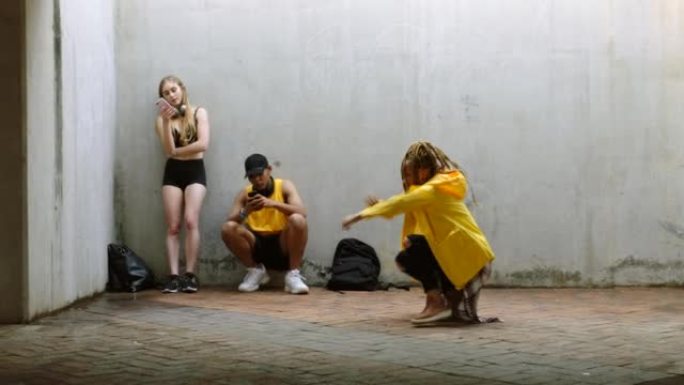 作为一群有影响力的舞者朋友，一名黑人妇女随着嘻哈音乐跳舞，他们在社交媒体的电话上直播。他们霹雳舞，互
