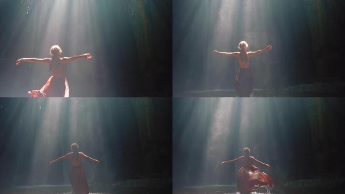 快乐的女人在瀑布洞穴里跳舞泼水穿着漂亮的衣服享受自然舞蹈感受精神自由4k
