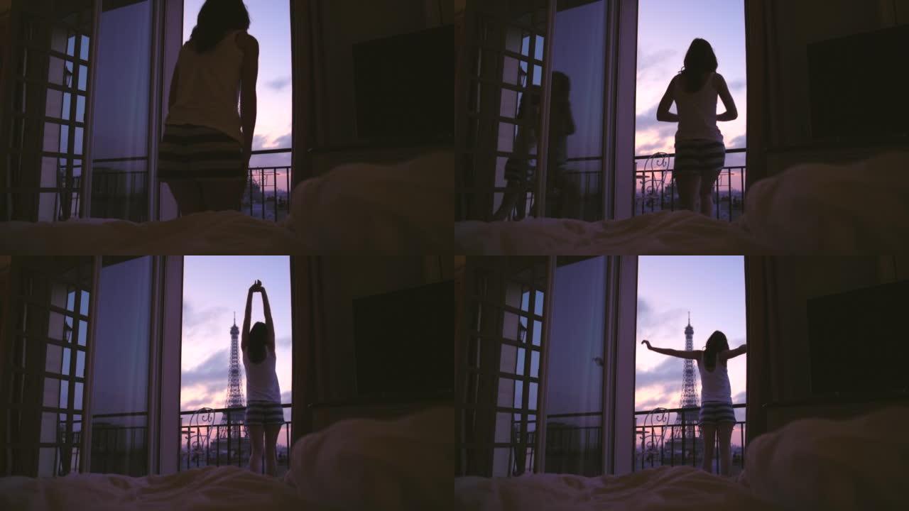 4k视频片段，一名年轻女子在俯瞰法国巴黎埃菲尔铁塔的公寓阳台上欣赏风景时伸展
