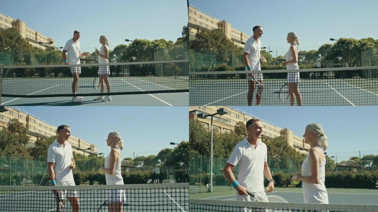 活跃的成熟夫妇穿着白色衣服在网球场上交谈