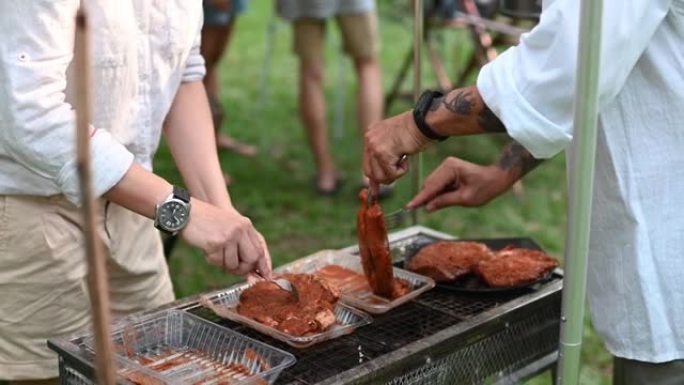 亚洲中国成熟夫妇的手在野营时为烧烤烧烤腌制调味肉
