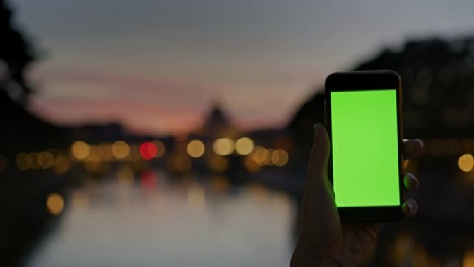 SLO MO无法识别的人使用带有色度键显示屏的智能手机在黄昏时拍摄Ponte Sant'Angelo