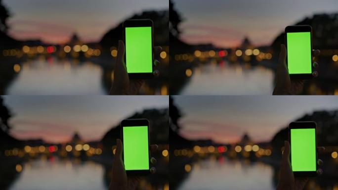 SLO MO无法识别的人使用带有色度键显示屏的智能手机在黄昏时拍摄Ponte Sant'Angelo