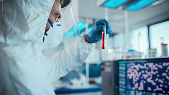 微生物学实验室: 穿着无菌工作服，面罩和口罩的科学家致力于计算机开发疫苗，药物，抗生素用血液样本拾取
