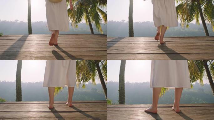 旅行女人的腿在甲板上行走，从日出4k度假生活方式看热带丛林的美丽景色