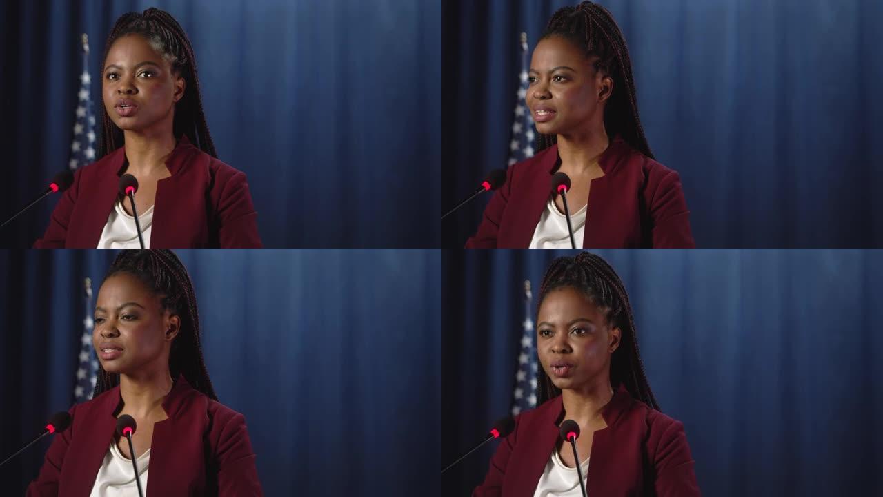 年轻的非洲裔美国政治家正在演讲，我们看到她在蓝色背景下的特写镜头