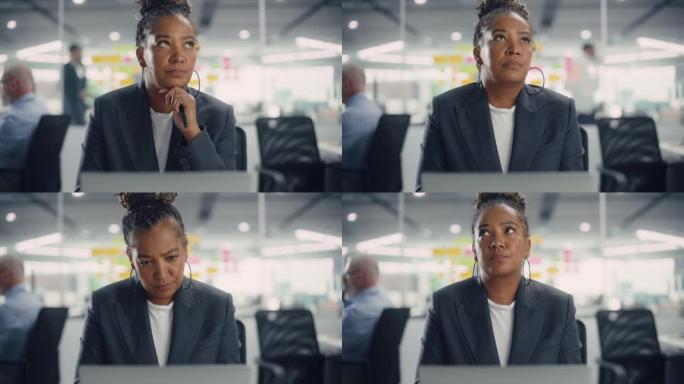 忙碌的非洲裔美国女经理在现代办公室使用电脑。过度劳累的员工处理艰苦的工作任务。压力很大的美女精疲力尽