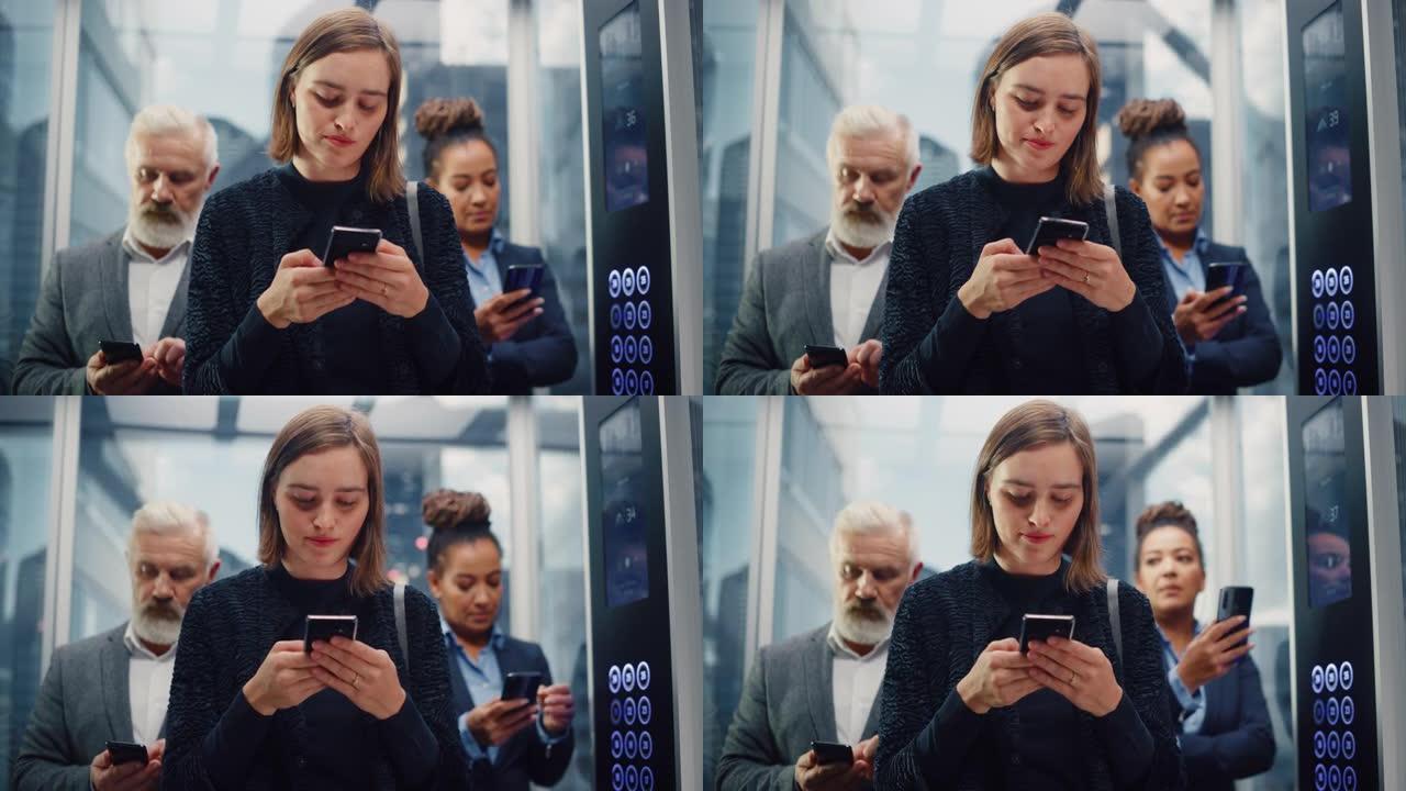 三个不同的多民族国际人士乘坐玻璃电梯在一个现代化的商务中心办公。专注于在电梯中使用智能手机的年轻漂亮