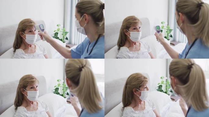 女卫生工作者在家检查老年妇女的体温