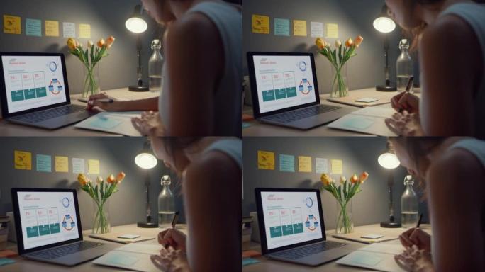 特写镜头年轻的亚洲商务女士自由职业者专注于笔记本电脑写工作表财务图表账户图表市场计划在家庭之夜。在家
