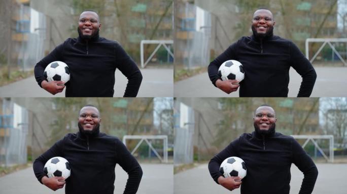 穿着运动服在城市球场上踢足球的非洲男子的肖像