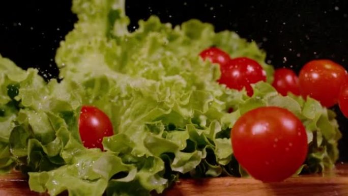 慢动作，特写: 新鲜生菜和弹跳的红色西红柿倒下