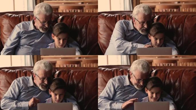 快乐的老爷爷和小孙子一起用电脑。