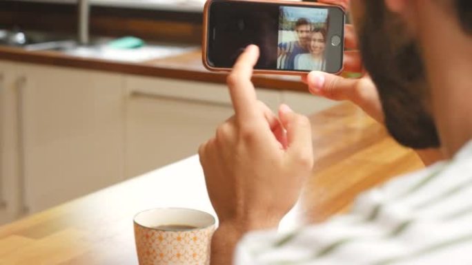 一名男子使用智能手机和一杯热气腾腾的茶的4k视频片段