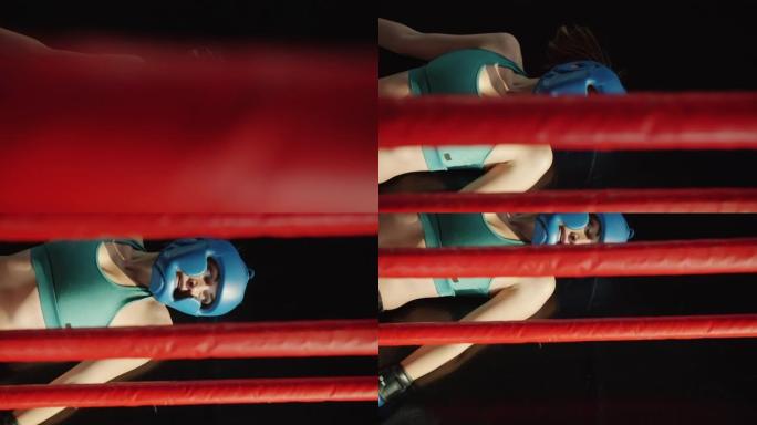 穿着拳击头盔和手套躺在戒指内垫子上的疲惫女运动员的俯视图
