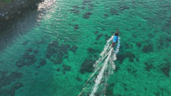 在蓝色绿松石海水披披岛上航行的长尾船的鸟瞰图。
