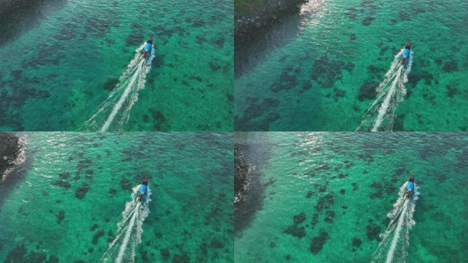 在蓝色绿松石海水披披岛上航行的长尾船的鸟瞰图。