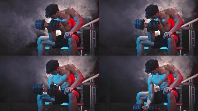 英俊的运动男子运动员在废弃的黑暗健身房用哑铃进行运动重量训练