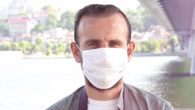 美丽的40多岁年轻千禧一代男子的特写肖像戴着面部医用白色口罩，抗冠状病毒新型冠状病毒肺炎大流行传染病