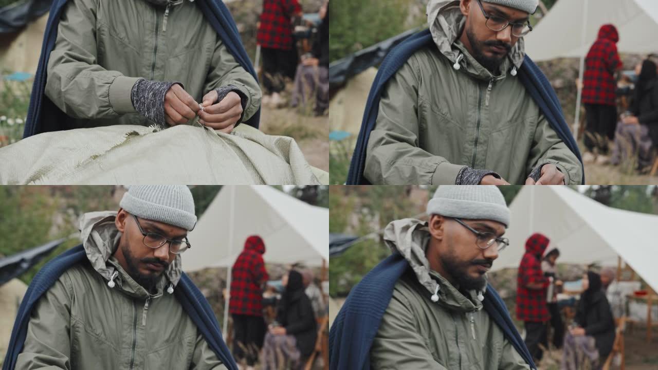 混合种族男子在难民营搭建帐篷