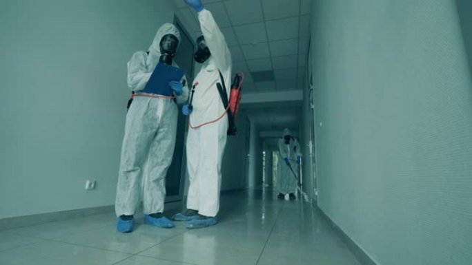 卫生工作者在走廊消毒时交谈