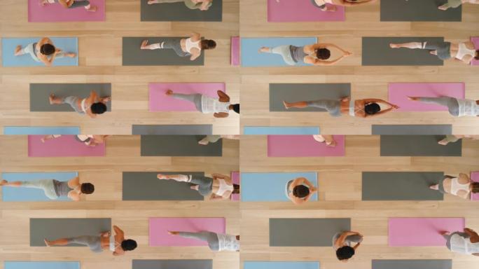 瑜伽课，女性锻炼和普拉提训练小组在健身工作室进行平衡，锻炼和伸展运动。以上，健康平衡和健康的生活方式