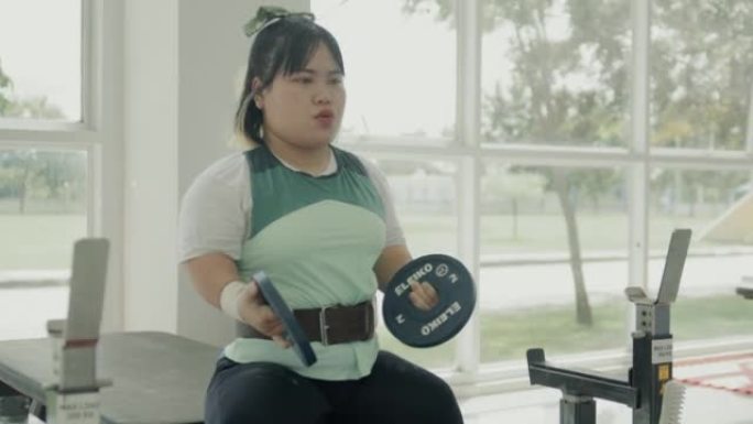 适应性亚洲女运动员准备在健身房锻炼。