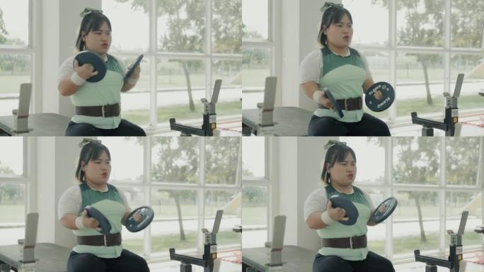 适应性亚洲女运动员准备在健身房锻炼。