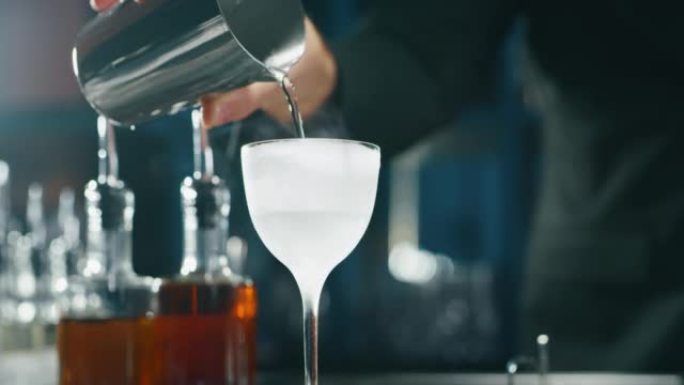 专业调酒师的特写镜头正在酒吧或迪斯科俱乐部为顾客准备精英酒鬼。