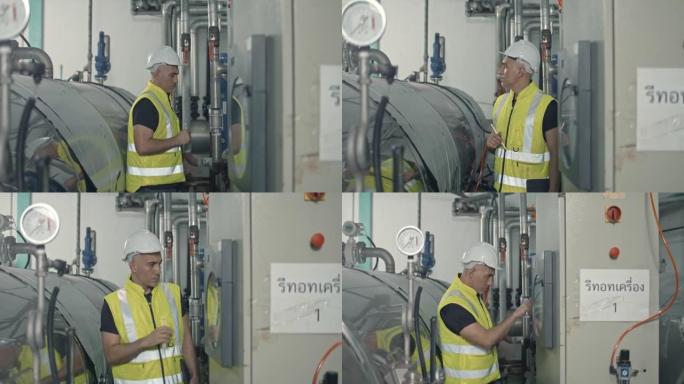 男工厂工人戴安全安全帽和制服使用笔记本电脑检查机器