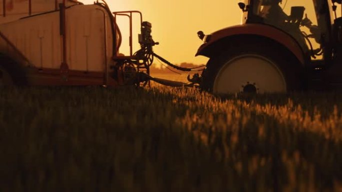 SLO MO Farmer在黄昏时使用拖拉机用农作物喷雾器的水灌溉田地