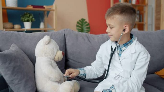 有趣的孩子玩泰迪熊用听诊器检查玩具独自享受游戏