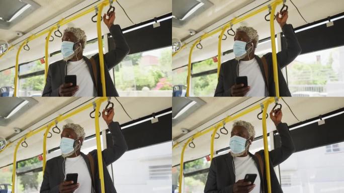 非裔美国高级男子站在公共汽车上使用智能手机戴口罩