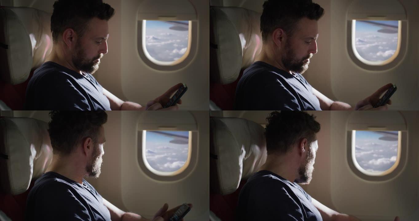 电影拍摄的年轻人使用智能手机通过飞机上的无线连接发送消息和技术应用程序，同时在国际航班度假旅行期间舒