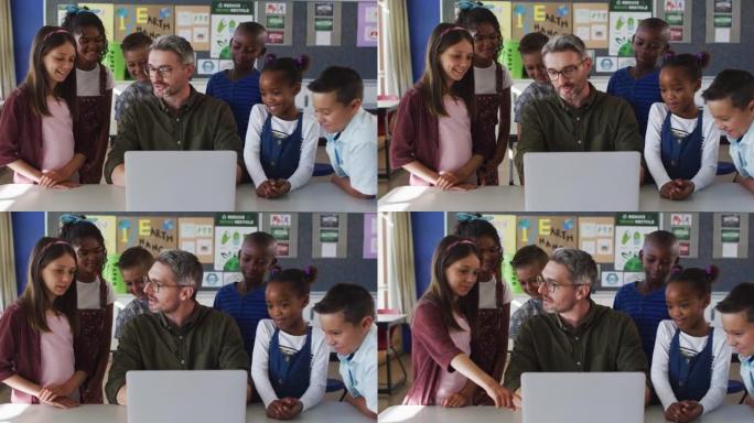 多元化的男老师和一群看着笔记本电脑的学童