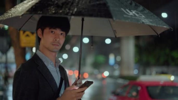 亚洲商人在雨天使用智能手机订购出租车
