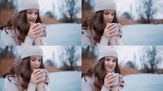年轻女子坐在冰冻的湖上喝热茶