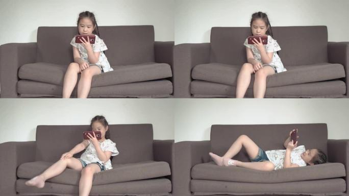 儿童小女孩使用智能手机在客厅沙发上放松