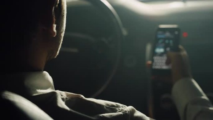 白天，一名男子在高档汽车上使用智能手机的肩膀镜头。一位商人在商务旅行期间使用GPS应用程序在城市中导