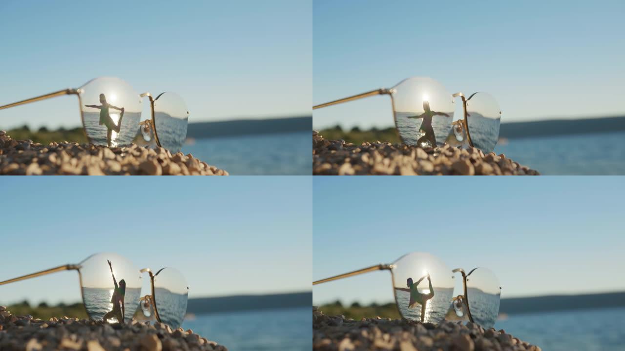 在海滩锻炼的女人的太阳镜中的倒影