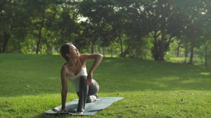 亚洲女子在公园用瑜伽伸展身体