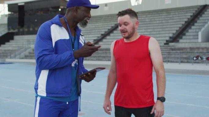 非裔美国男教练和高加索运动员在训练期间交谈