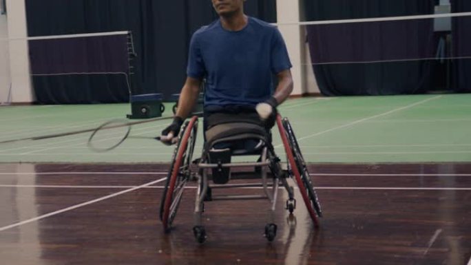 亚洲残疾人羽毛球运动员坐在轮椅上与朋友打羽毛球。