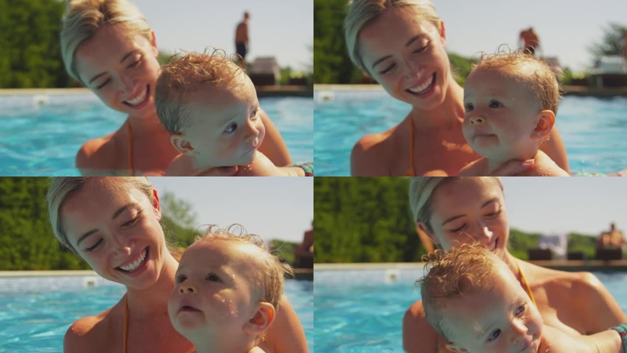 男婴和母亲一起度过家庭暑假，在游泳池里玩得开心